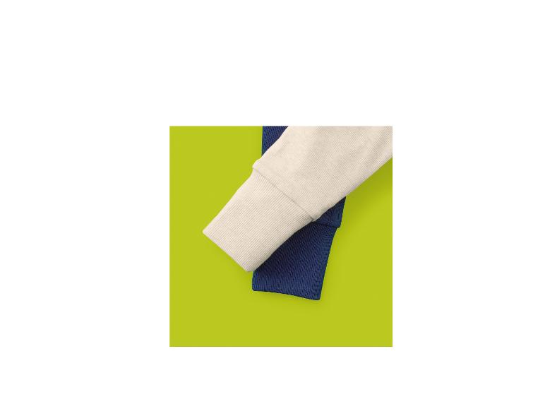 Twee geribbelde stoffen mouwen, één crème en één marineblauw, op een limoengroene achtergrond.