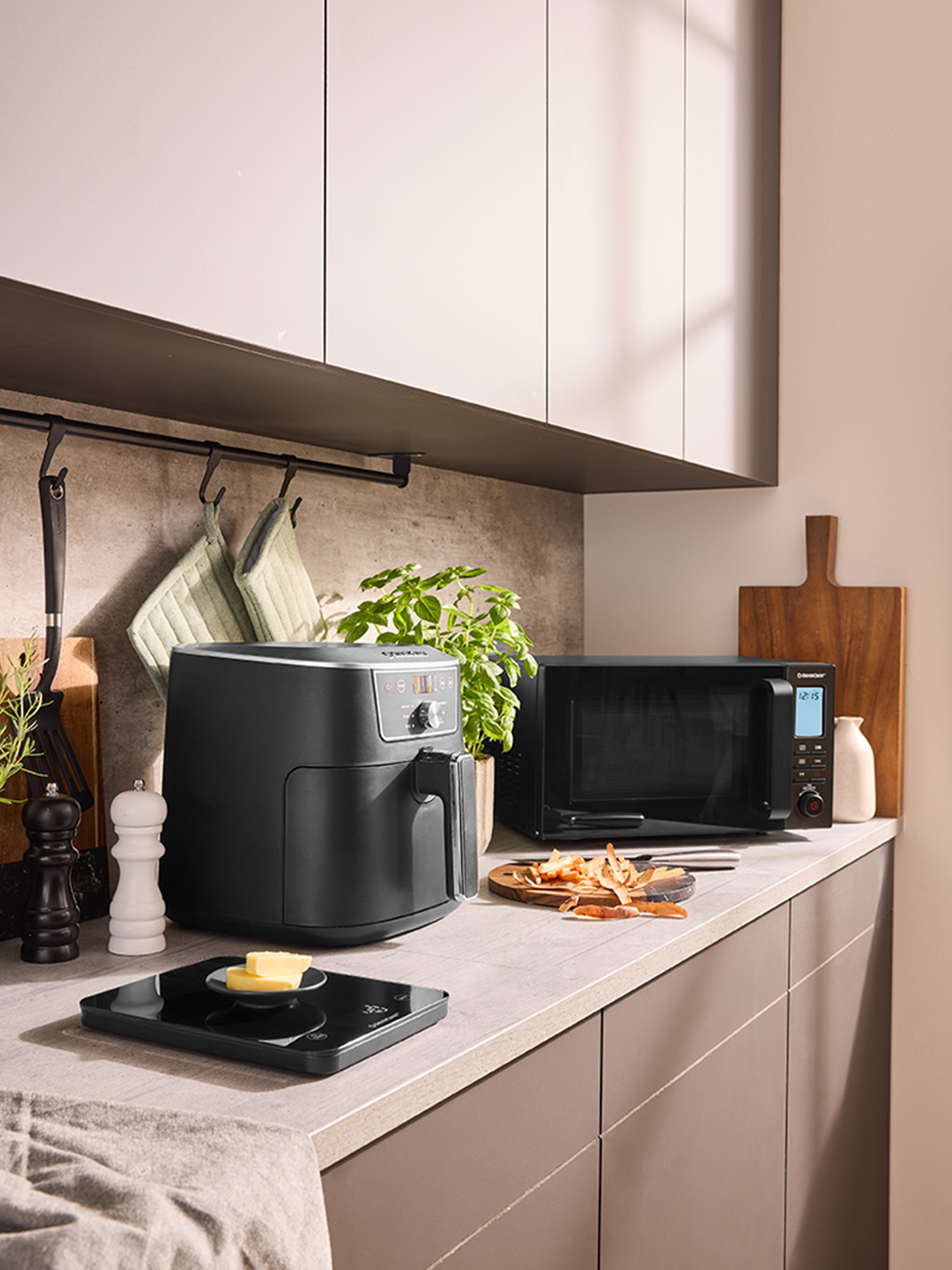 Een airfryer en een magnetron op een modern aanrecht.