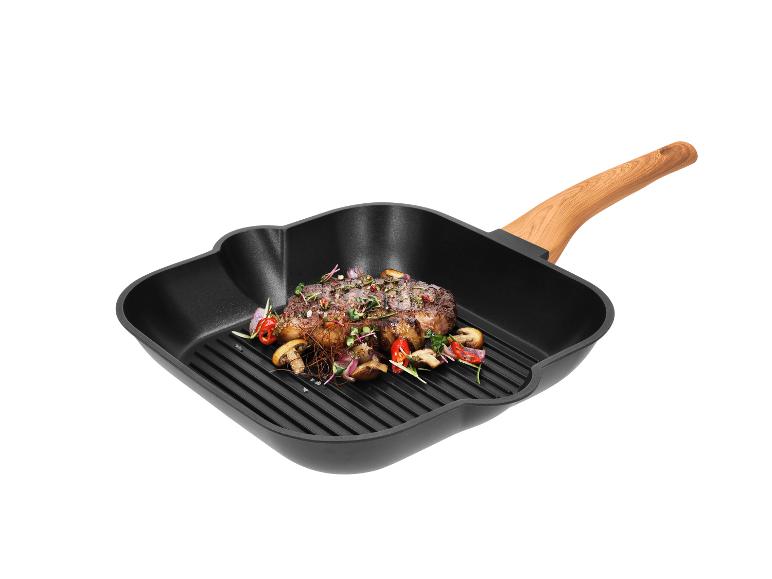 Gegrilde biefstuk met groenten in een zwarte vierkante grillpan met houten handvat.
