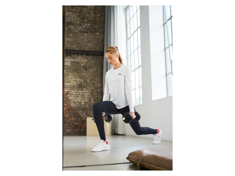 Vrouw in wit shirt met lange mouwen en zwarte legging doet lunges met dumbbells.