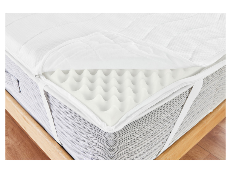 Een wit matras met een topper van schuim.