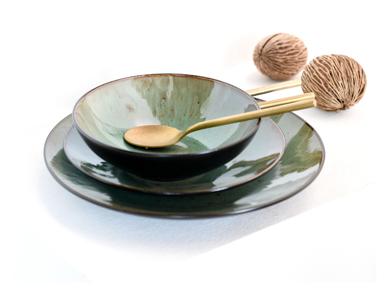 Donkergroene keramische schaal en borden, gouden lepel.