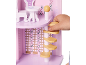 Kinderhand speelt met een roze houten poppenhuis, met meubels en een wenteltrap.