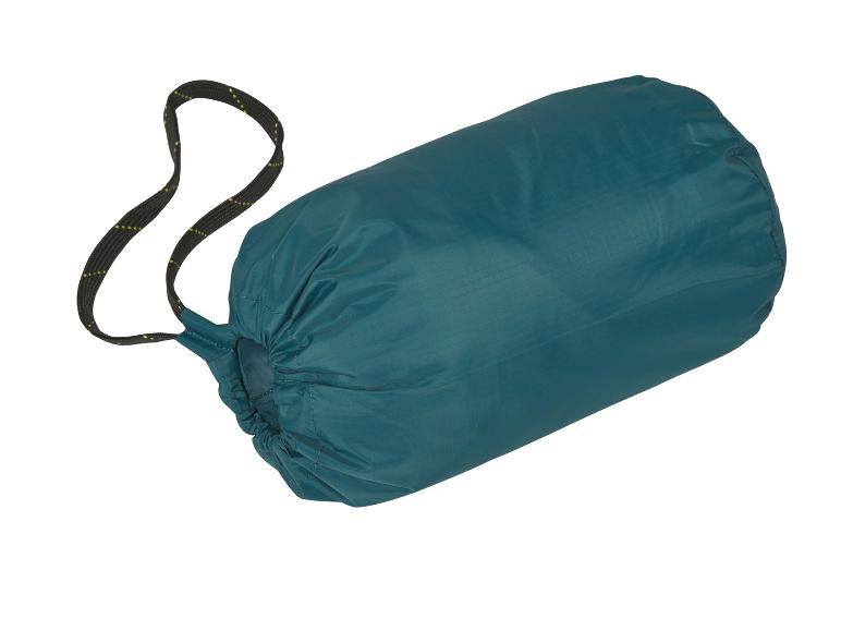 Een groene slaapzak in een opbergzak.