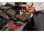 Man laadt telefoon met lege batterij op met een auto-startbooster.