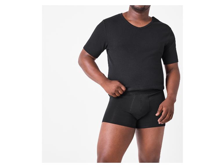 Man in een zwart V-hals T-shirt en zwarte boxershorts.