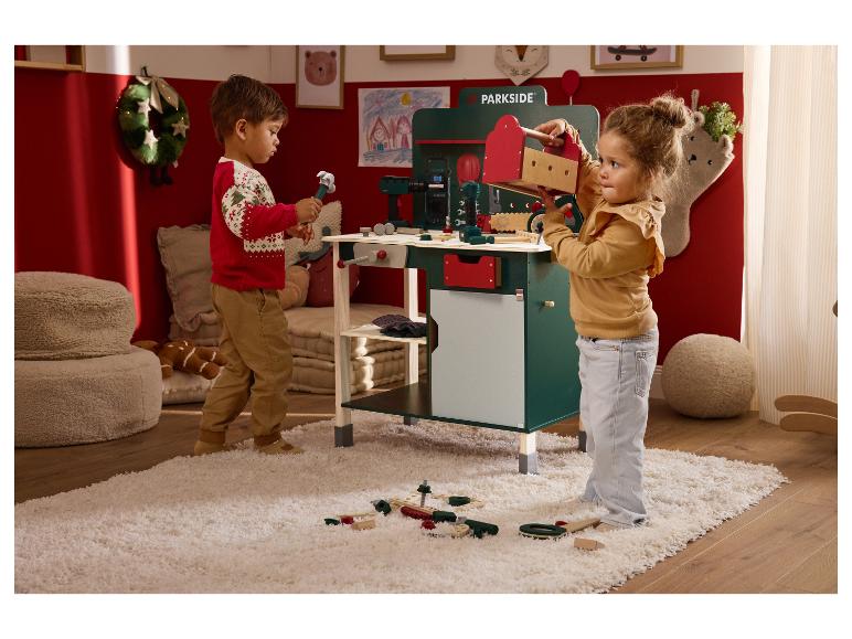 Twee kinderen spelen met een Parkside speelgoedwerkbank en gereedschap.