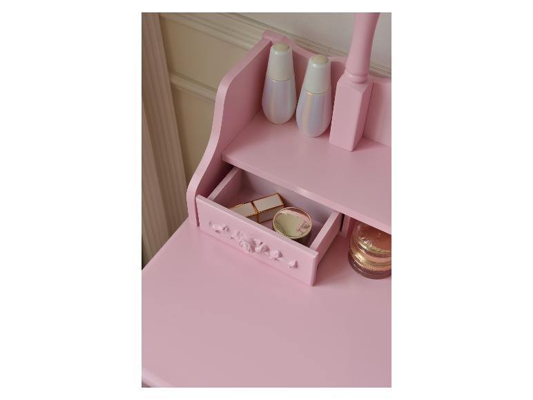 Roze kaptafel met open lade, cosmetica en decoratieve flessen.