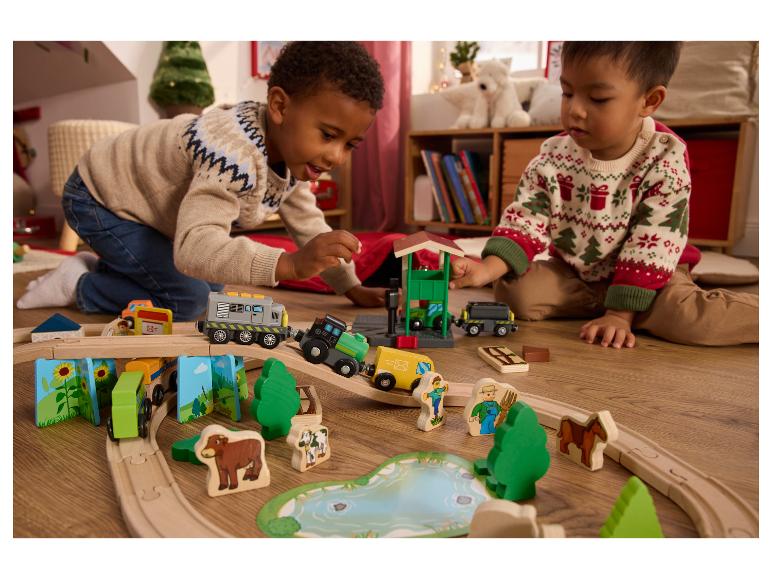 Twee kinderen spelen met een houten trein en boerderij speelset.