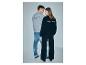 Man en vrouw in grijze en zwarte sweatshirts met tekst 