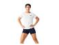 Vrouw in wit T-shirt en donkerblauwe korte broek, handen in de zij.
