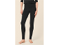 Vrouw in zwarte legging en zwarte top, staat op blote voeten.