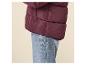 Bordeauxrode damespufferjas en jeans.