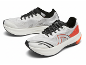 Een paar witte en oranje hardloopschoenen met zwarte veters, van de zijkant gezien.