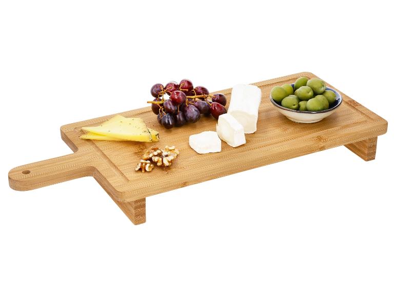 Houten snijplank met kaas, druiven, walnoten en olijven