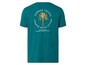 Een turquoise T-shirt met een palm-print en de tekst 'Summer Travel Beach Club'.