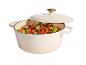 Crèmekleurige braadpan met deksel, gevuld met kleurrijke groenten en aardappelen.