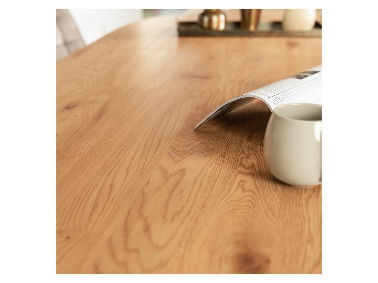 Houten tafel met krant en mok, decoraties op de achtergrond.