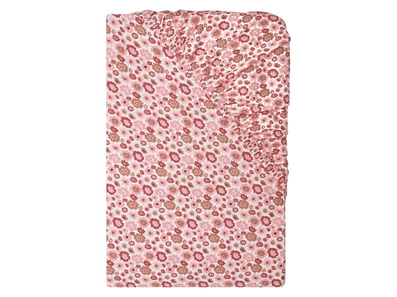 Hoeslaken voor wieg met roze en bruin bloemenpatroon.