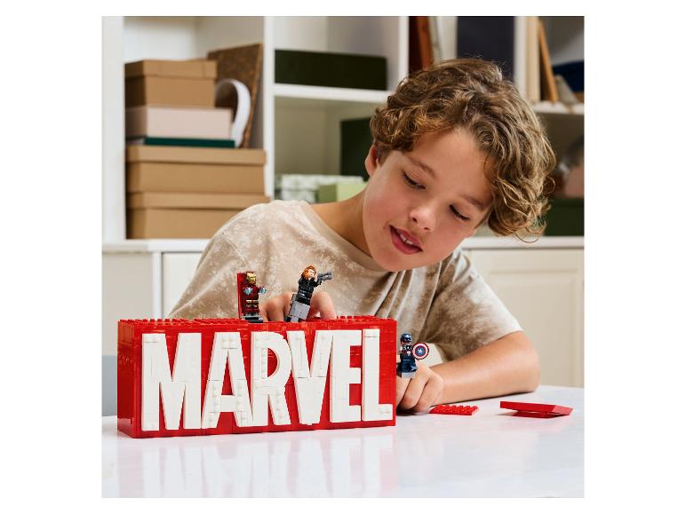 Jongen speelt met LEGO Marvel-logo en minifiguren van Iron Man, Black Widow en Captain America.