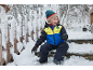 Lachend kind in ski-jas en sneeuwbroek zit op besneeuwde treden.