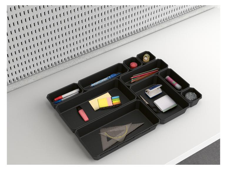 Zwarte bureau-organizer met kantoorbenodigdheden zoals potloden, paperclips en notitieblokken.