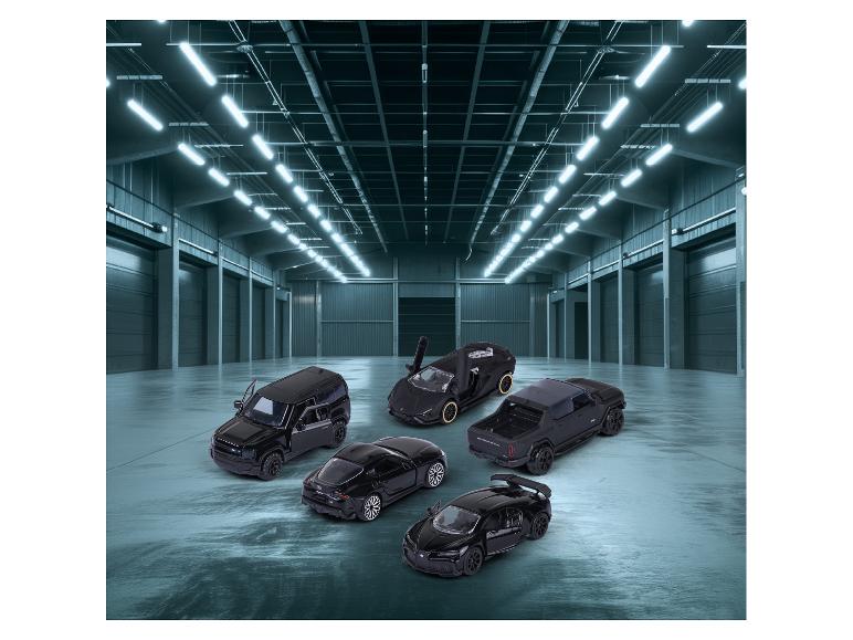 Zwarte speelgoedauto's, waaronder een Land Rover Defender en een Bugatti Chiron, in een magazijn.
