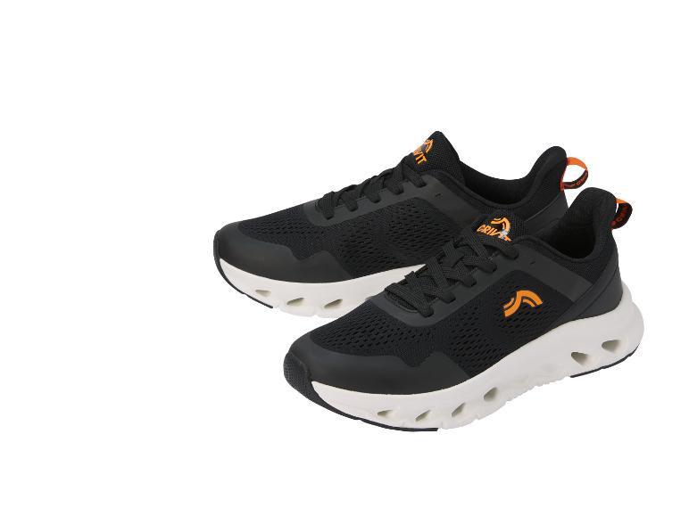 Zwarte sportschoenen met oranje details en een witte zool met gaten.
