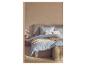Slaapkamer met een bed met blauw-wit geruit beddengoed, een beige plaid en decoratieve kussens.
