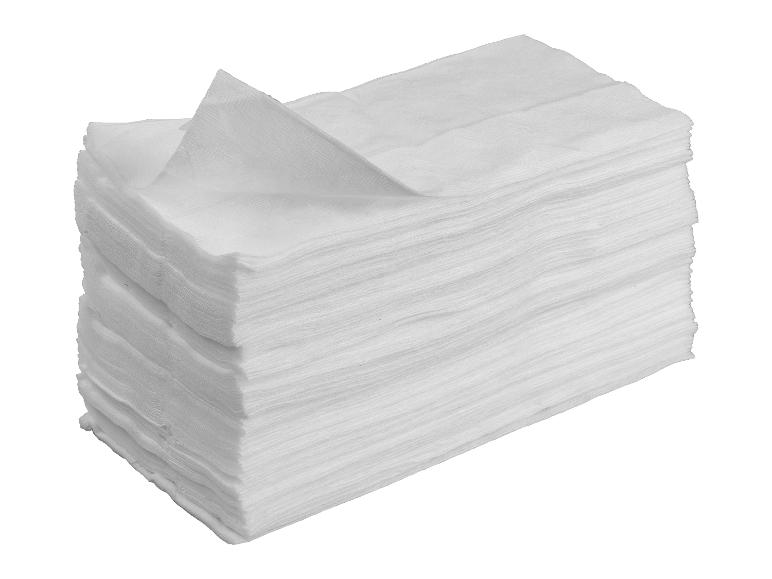 Een stapel witte papieren servetten met het bovenste servet gedeeltelijk uitgevouwen.