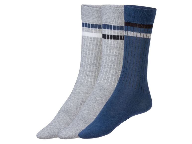 Drie paar sokken: twee grijs, één blauw met witte en zwarte strepen.