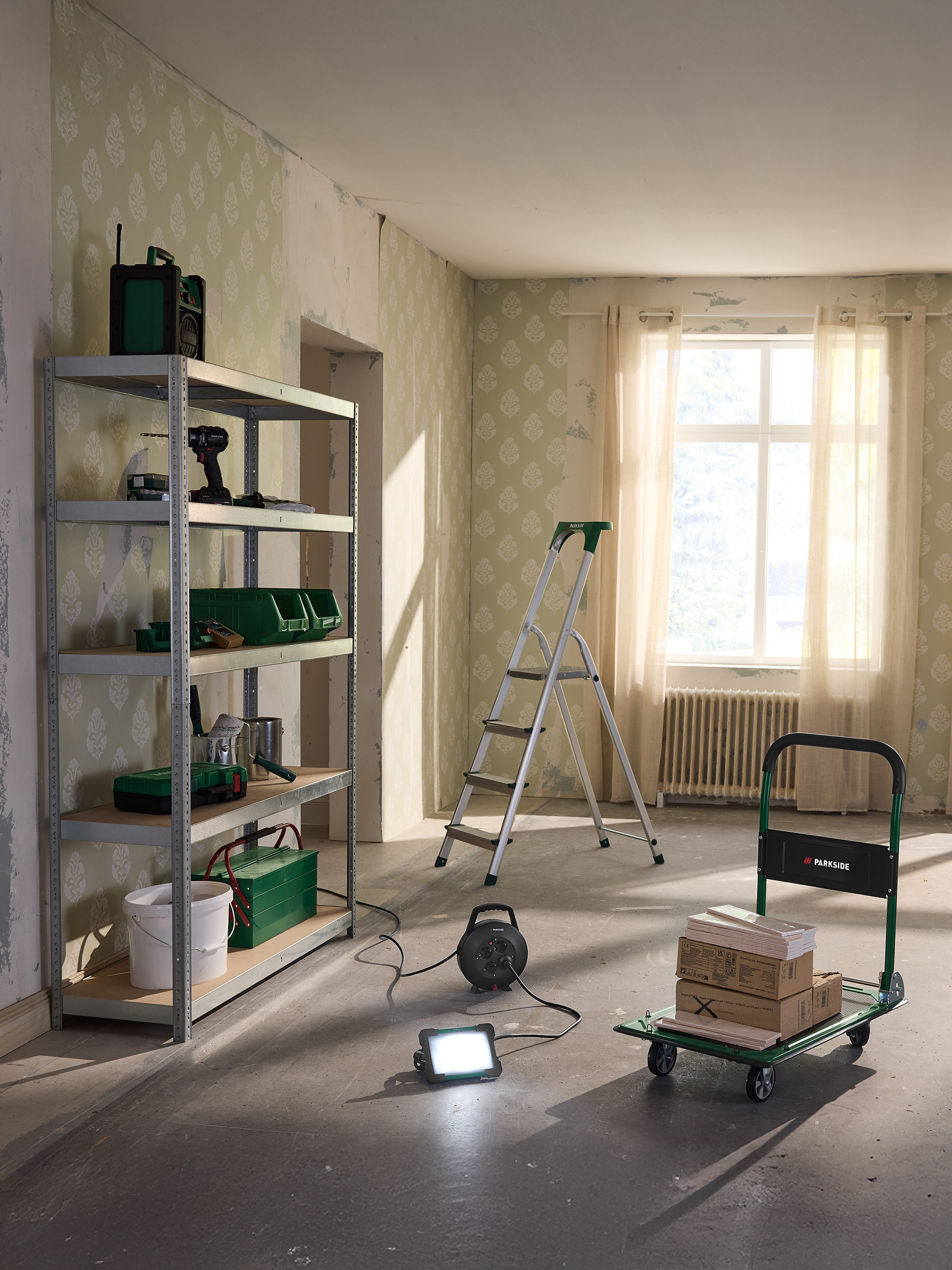 Opbergrek, trap en transportkar in een te renoveren kamer.