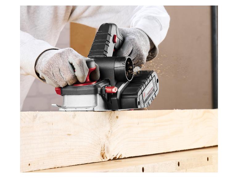 Draadloze elektrische schaafmachine in actie, met houtsnippers die van een houten plank vliegen.