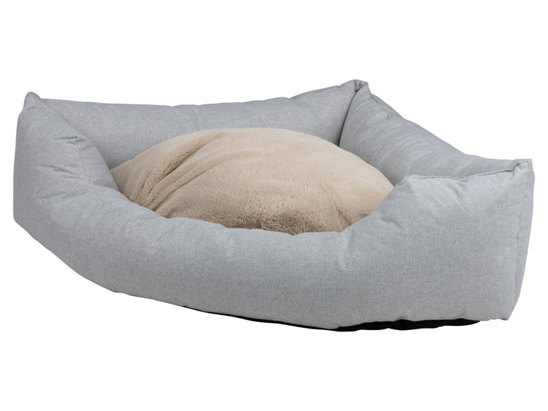 Een grijze hondenmand met een beige pluche kussen.