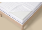 Matras met open hoes en schuimlaag, op een houten bedframe.
