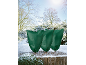 Drie groene plantenbeschermhoezen in een besneeuwd winterlandschap.
