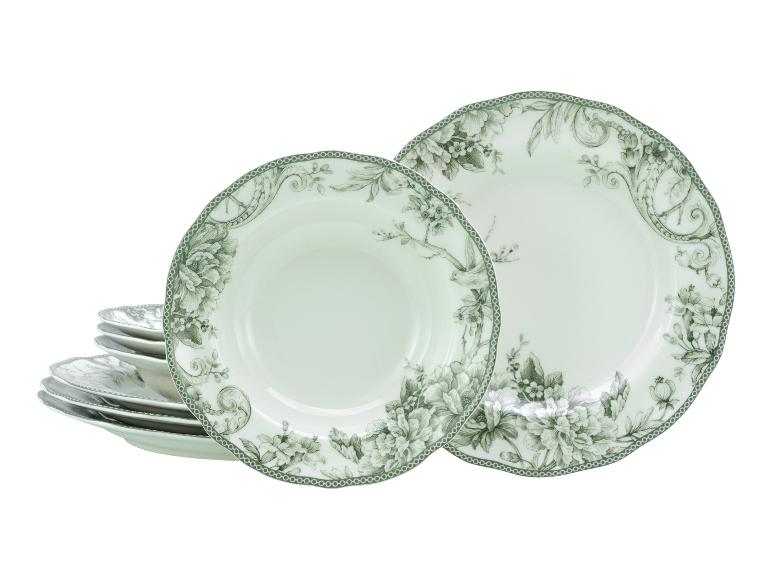 Wit servies met groene bloemmotieven, inclusief borden en kommen.