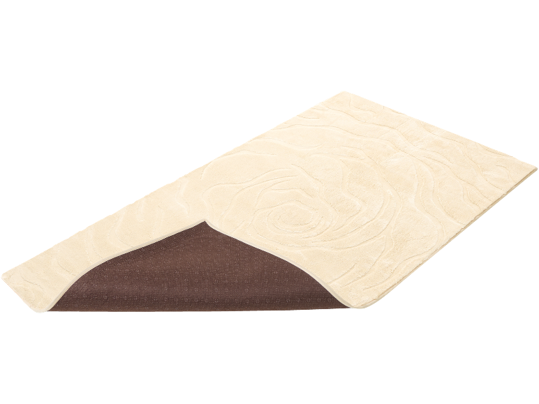 Beige vloerkleed met golvend patroon en bruine antislip onderkant.