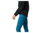 Vrouw in zwart sportjack en blauwe sportlegging met zijzakken.