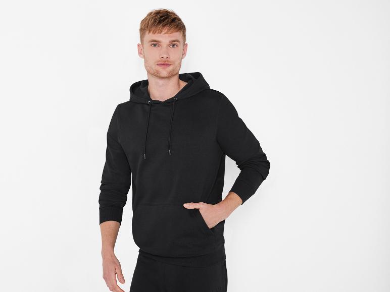 Man in een zwarte hoodie met capuchon.