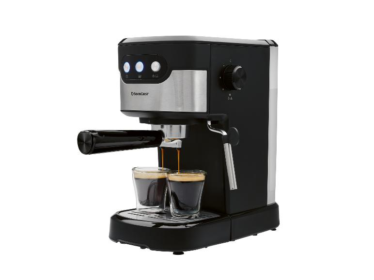 Zwart-zilveren espressomachine die koffie in twee kleine glazen schenkt.