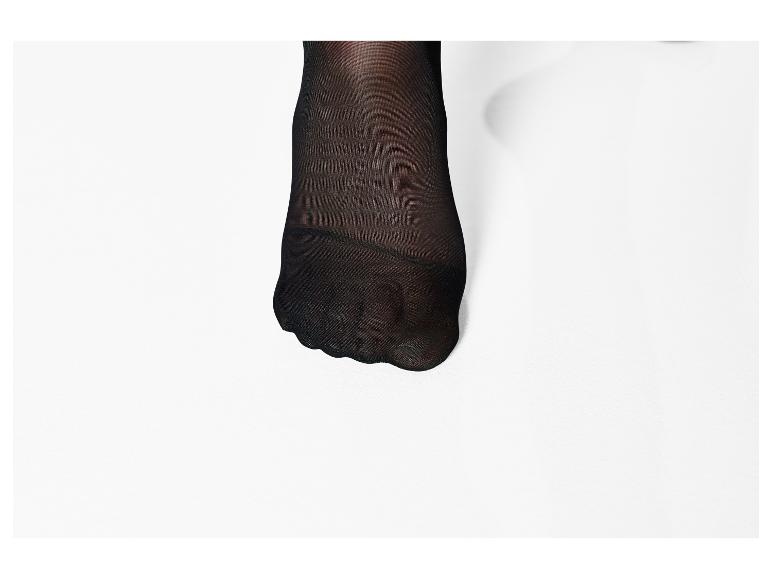 Voet in zwarte panty op witte achtergrond.