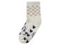 Witte pluizige sok met beige ruitpatroon en zwarte hartjes.