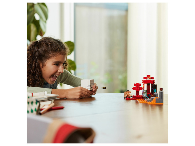 Een meisje speelt met LEGO Minecraft figuren, waaronder een Skelet en een Nether-portaal.