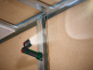 Magnetische werklamp verlicht een muur met metalen profielen en houten panelen.