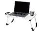 Witte opvouwbare tafel met een laptop en een grijze mok.
