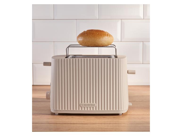 SilverCrest broodrooster met broodje op houten tafel voor witte tegels.