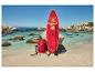 Rood SUP board met peddel, tas en pomp op zandstrand met turquoise water.