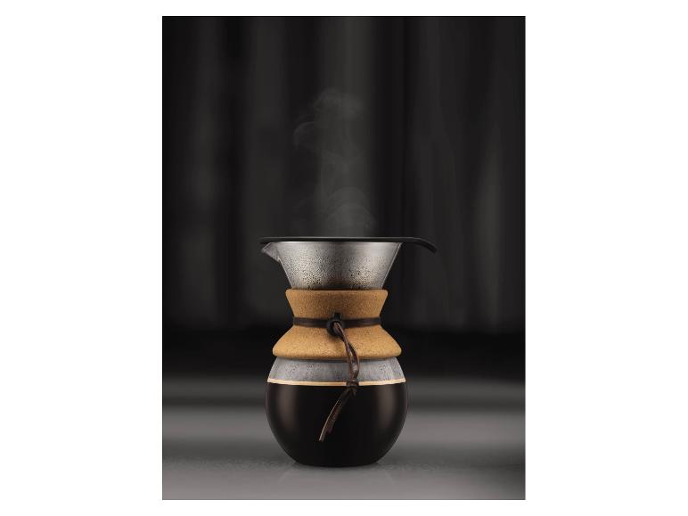 Glazen koffiekan met kurken band en stoom van koffie.