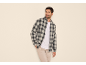 Man in geruit overhemd, wit T-shirt en beige broek